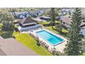 Aerial view of a community pool with lounge chairs surrounded by grass and trees at 900 Avenue Z Se # A3, Winter Haven, FL 33880