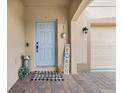 Close up of home's covered entry and blue front door with brick paver flooring at 10234 Lenox St, Clermont, FL 34711