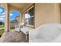 Charming front porch with brick floors, white furniture and detailed columns creating an inviting space at 10234 Lenox St, Clermont, FL 34711