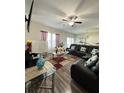 Spacious living room with modern decor, a ceiling fan, and plenty of natural light at 1056 Naes Ln, Lake Wales, FL 33853