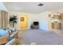 Inviting living room featuring neutral carpeting and open access to the kitchen and hallway at 11 Sun Air Blvd E, Haines City, FL 33844