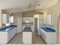 Spacious kitchen featuring white cabinets, a center island, and modern appliances, perfect for cooking and entertaining at 1106 Partridge Way, Kissimmee, FL 34759