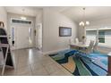 Bright dining room with modern lighting, elegant white table set, and tiled flooring at 135 Krenson Bay Loop, Winter Haven, FL 33881
