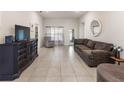 Spacious living room with tiled floors, comfortable seating, and ample natural light at 135 Krenson Bay Loop, Winter Haven, FL 33881