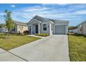 An inviting one story home with a grey exterior, manicured lawn, and a spacious driveway at 1998 Sarah St, Winter Haven, FL 33884