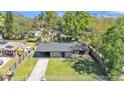 Aerial view of a charming home with a lush backyard and covered parking space at 210 Pinehurst Dr, Auburndale, FL 33823