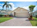 Charming single-Gathering home with a well-manicured lawn, beautiful landscaping, and a brick paver driveway at 225 Highgate Park Blvd, Davenport, FL 33897