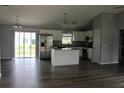 Open-concept kitchen featuring stainless steel appliances, gray granite countertops and island with modern white cabinets at 2487 Sw 170Th Loop, Ocala, FL 34473