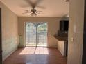 Open dining area with a ceiling fan, view to the backyard through sliding doors, and access to kitchen at 261 Acacia Walk, Lake Wales, FL 33898