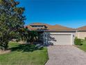 Charming single-story home with brick driveway, attached garage, and lush green lawn at 3014 Ashton Palms Dr, Lake Wales, FL 33859