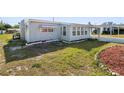Exterior view of a light blue single-story home with well maintained landscaping at 319 Thomas Ave, Frostproof, FL 33843