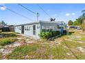 Exterior view of a light blue single-story home with satellite dishes at 319 Thomas Ave, Frostproof, FL 33843