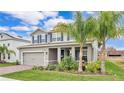 Beautiful exterior with blue shutters and a brick driveway, complemented by lush landscaping and a palm tree at 3217 La Salle St, Winter Haven, FL 33884