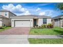 Charming one-story home featuring a two-car garage, blue front door, concrete driveway, and well-maintained landscaping at 336 Summer Squall Rd, Davenport, FL 33837