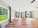 Bright living room with hardwood floors, large windows, and stylish curtains at 3736 Knights Station Rd, Lakeland, FL 33810