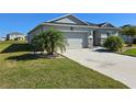 Inviting single-story home with a well-maintained lawn and a two-car garage with a large driveway at 398 Quarry Rock Cir, Kissimmee, FL 34758
