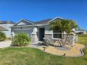 Beautifully landscaped single-story home featuring stone accents, palm trees, and a well-manicured lawn at 398 Quarry Rock Cir, Kissimmee, FL 34758