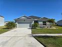 Charming single-story home with a well-manicured lawn, with a two-car garage and driveway at 398 Quarry Rock Cir, Kissimmee, FL 34758