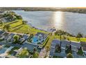 Scenic aerial view of community amenities including a pool, clubhouse, and lake access with an expansive waterfront at 4016 Cypress S Lndg, Winter Haven, FL 33884