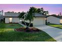 Charming single-story home featuring a well-manicured lawn and a two-car garage at sunset at 4016 Cypress S Lndg, Winter Haven, FL 33884
