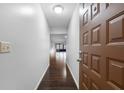 Inviting hallway with dark hardwood floors leading to a bright living area, showcasing the home's open layout at 4016 Cypress S Lndg, Winter Haven, FL 33884