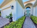 Inviting entryway with a colorful front door, lush landscaping and brick paver walkway at 4088 Dunmore Dr, Lake Wales, FL 33859