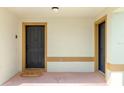 Front door, with black paint, sits behind covered porch and home sweet home door mat at 438 Monroe Cir, Davenport, FL 33896
