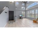 Inviting living room with soaring ceilings, large windows, tile flooring, and a cozy rocking chair at 438 Monroe Cir, Davenport, FL 33896