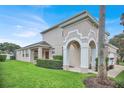 Beautiful two-story home featuring an arched entryway, a lush green lawn, and well-maintained landscaping at 451 Montara Dr, Davenport, FL 33897