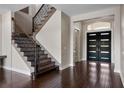 Elegant foyer with dark wood floors, a staircase with iron railings, and a grand entrance at 4717 Emerald Palms Ct, Winter Haven, FL 33884