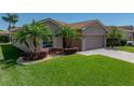 Well maintained single-story home featuring a brick driveway, tropical landscaping and a two-car garage at 5325 Nicklaus Dr, Winter Haven, FL 33884