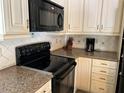 Close up of kitchen features, black stove, microwave, and custom countertops at 5512 Meander Ln, Lake Wales, FL 33898