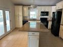 Spacious kitchen featuring an island, black appliances, and custom cabinets at 5512 Meander Ln, Lake Wales, FL 33898