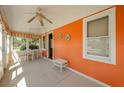 Bright sunroom with a ceiling fan, table with 4 chairs and an orange accent wall at 555 Morrel Ave, Lake Wales, FL 33859