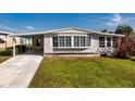 Charming single-story home with a covered carport and manicured lawn on a sunny day at 6433 Jacaranda Ne Ave, Winter Haven, FL 33881
