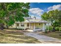Inviting two-story house with a concrete driveway, lush trees and well manicured grounds at 819 Seminole Rd, Babson Park, FL 33827