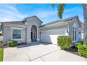 Stylish single-story home boasts a two-car garage, well-maintained landscaping, and a stucco exterior with a welcoming entrance at 908 Orista Dr, Davenport, FL 33897