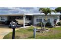 Charming home with a boat parked in the carport, on a sunny day at 121 Bonnie Dr, Auburndale, FL 33823