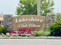 Lakeshore Club Villas community sign featuring stone pillars and colorful flower beds at 1219 Club Cir, Lakeshore, FL 33854