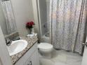 Bright bathroom featuring a granite vanity top, a sleek sink, and a bathtub with shower at 1393 Axel Cir, Winter Haven, FL 33880