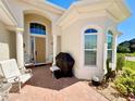 Inviting front porch area with brick pavers, decorative elements, and seating for relaxing at 1402 Colonial Ct, Winter Haven, FL 33884