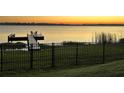 Beautiful sunset view of the community dock with seating by the lake at 169 Summershore Dr, Auburndale, FL 33823