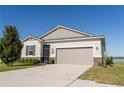 Charming single-story home featuring a two-car garage and beautifully landscaped front yard on a clear, sunny day at 169 Summershore Dr, Auburndale, FL 33823