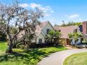 Charming two-story home with mature landscaping, a lush lawn, and a long driveway at 2 Bridgewater Dr, Winter Haven, FL 33884