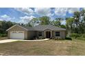 Charming single-story home featuring a two-car garage, well-maintained lawn, and delightful landscaping at 214 Brook Ln, Polk City, FL 33868