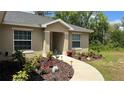 Inviting home entrance with a curved walkway, manicured landscaping, and a welcoming front door at 214 Brook Ln, Polk City, FL 33868