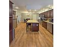 Open kitchen with stainless steel appliances, granite countertops, an island and dark wood cabinets at 218 Omaha St S S St, Lake Hamilton, FL 33851