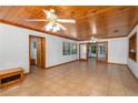 Bright living room with tile floors, wood ceiling, white walls, and multiple ceiling fans at 225 Wes Mann Rd, Babson Park, FL 33827