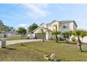 Beautiful two-story home with a two-car garage, long driveway, and lush green lawn with tropical landscaping at 247 Cobalt Dr, Kissimmee, FL 34758