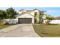 Charming two-story home featuring a two-car garage and a well-manicured lawn with palm trees at 247 Cobalt Dr, Kissimmee, FL 34758